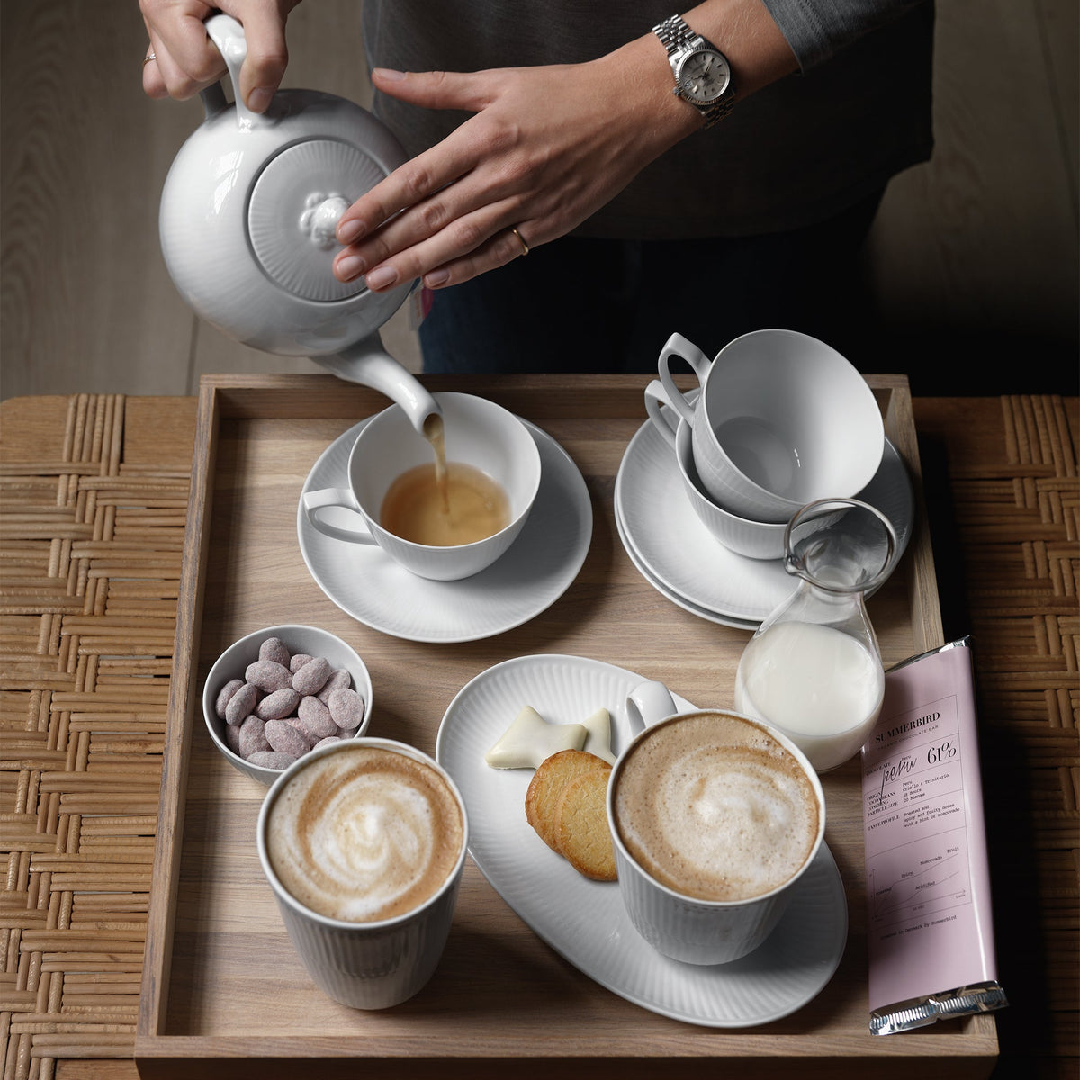 Tasse, théière et assiette Weiß Gerippt de Royal Copenhagen sur une table de café